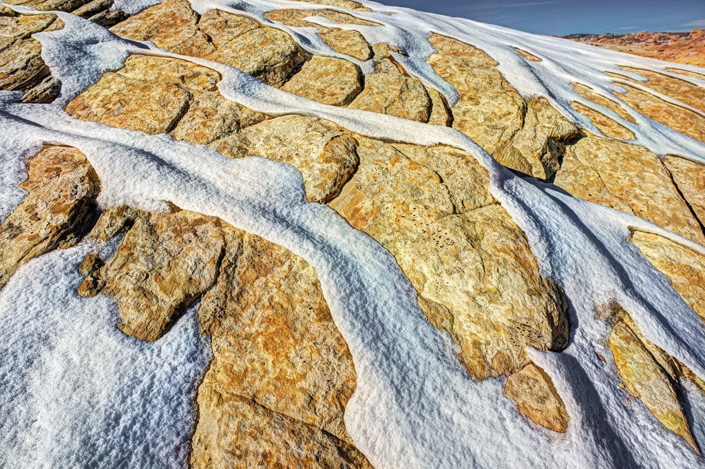 Melting snow on sandstone in the San Rafael Reef of Utah by Gary Orona