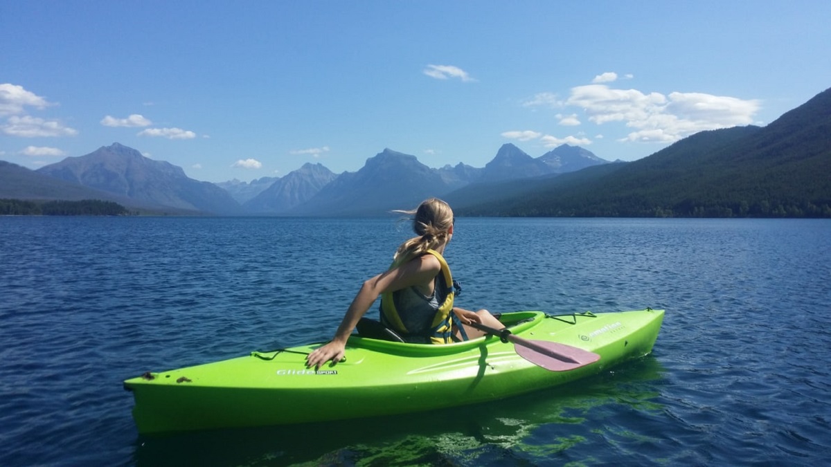woman in a green kayak on body of water