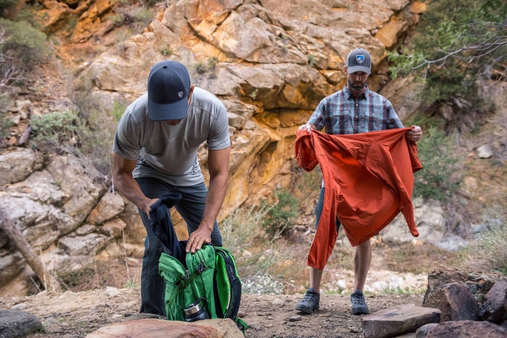 two men holding hiking gear