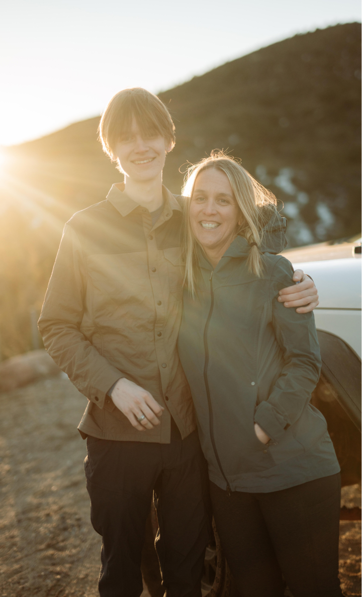 Mom embracing her teenage son in the backcountry both dressed in KUHL clothing