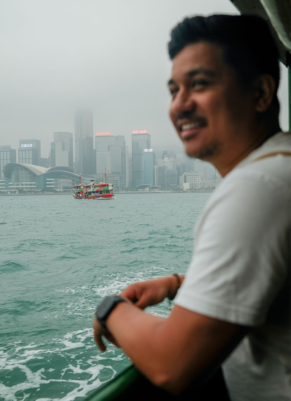 Ryan blurred on a boat ride with Honk Kong in focus in the background