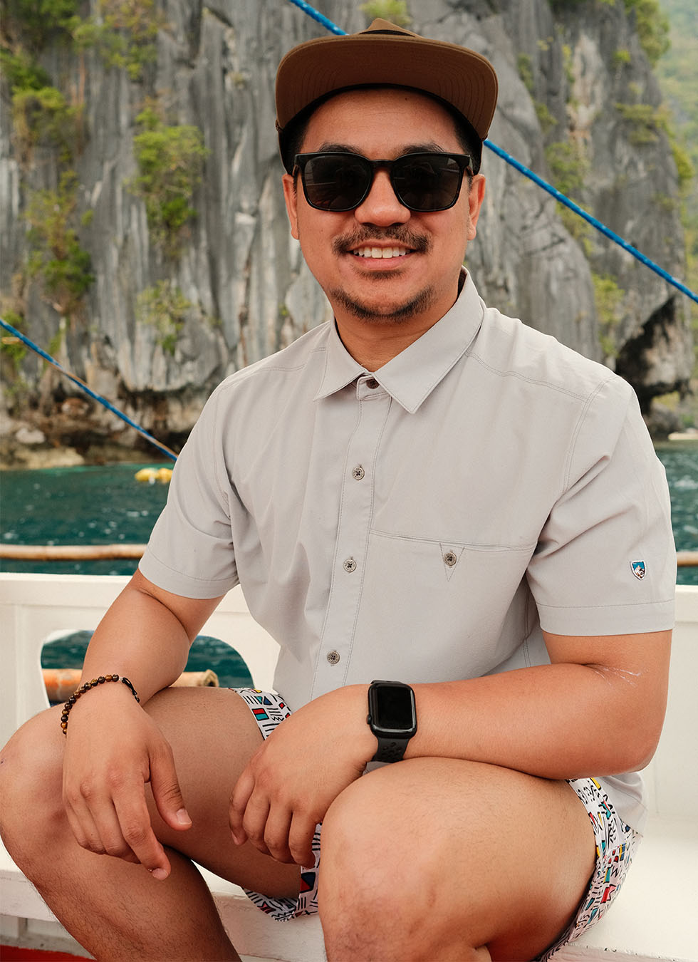 Ryan enjoying a boat ride in Philippines wearing KUHL men's summer clothing