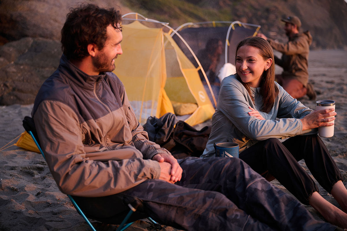 A man and a woman tent camping and enjoying a sundown