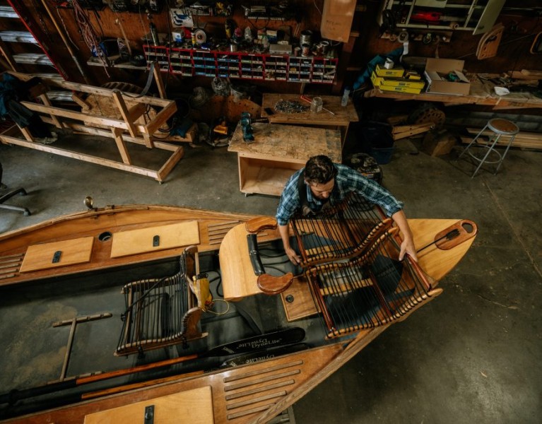 A man making a craft, custom Cajune boat.