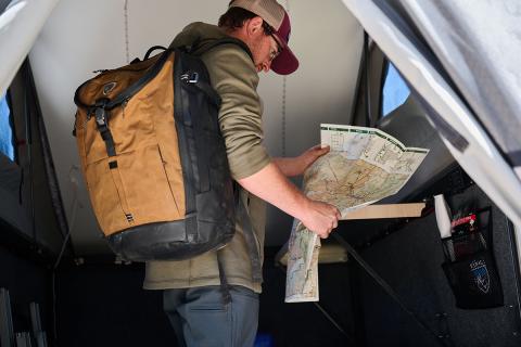 man with a backpack reading a map
