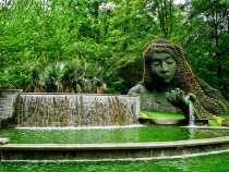 The image shows the iconic Earth Goddess (sometimes called "Mother Earth" or "Gaia"), a massive 25-foot-tall living plant sculpture in the Cascades Garden.