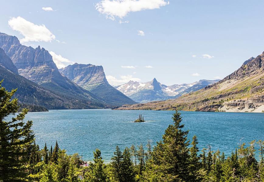 A large body of water surrounded by mountains - Glacier National Park