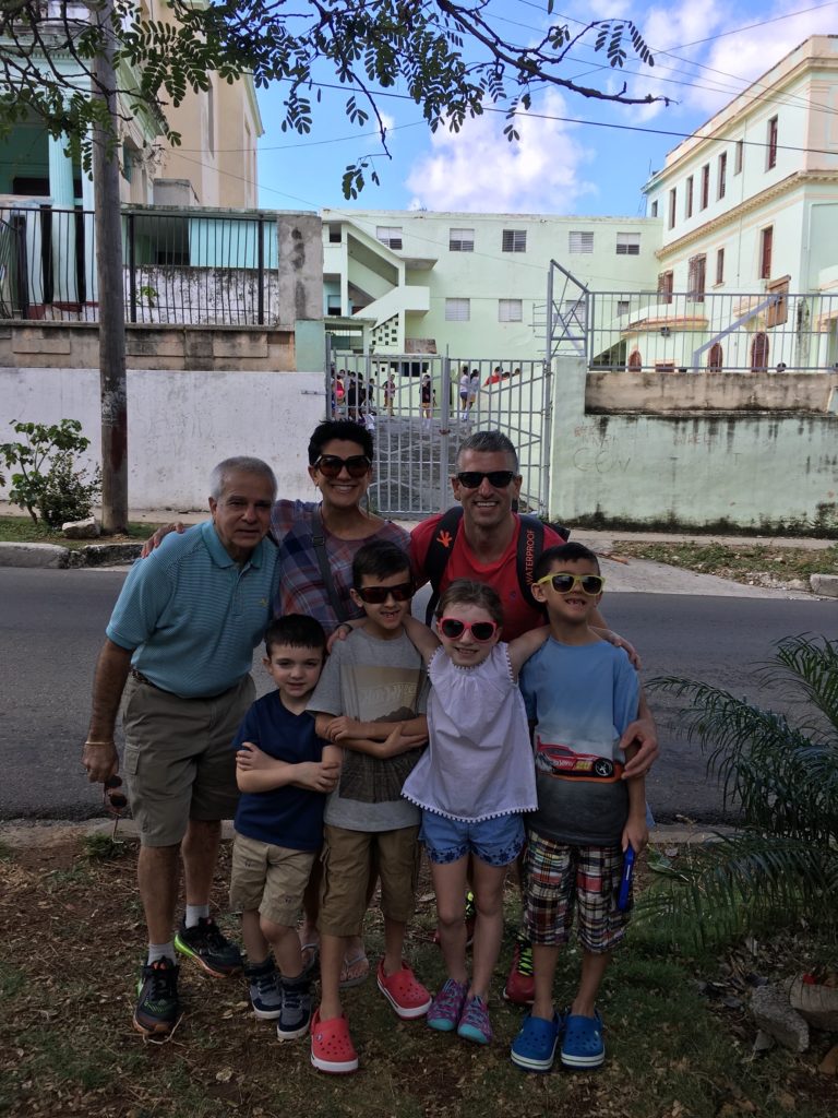 A KUHL Ambassador standing with a local familiy from Cuba