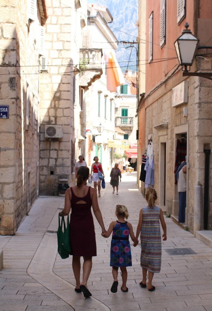 Mom and two daughters walk holding hands in Croatia.