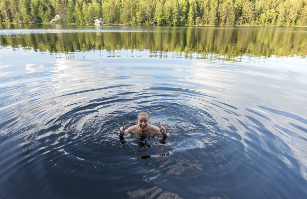 A woman enjoying a swim in Nuuksio National Park in Finland.