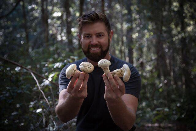 Forrest Galante holding mushrooms in a forest