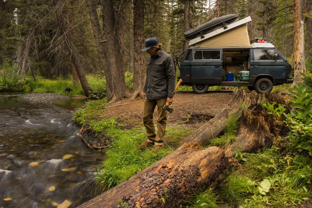 Bearanoid article image - Man in KUHL clothing standing near a creek with a van in the back.