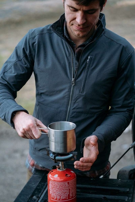 man cooking on a camp stove