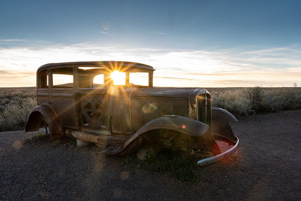 Rusting car at sunset