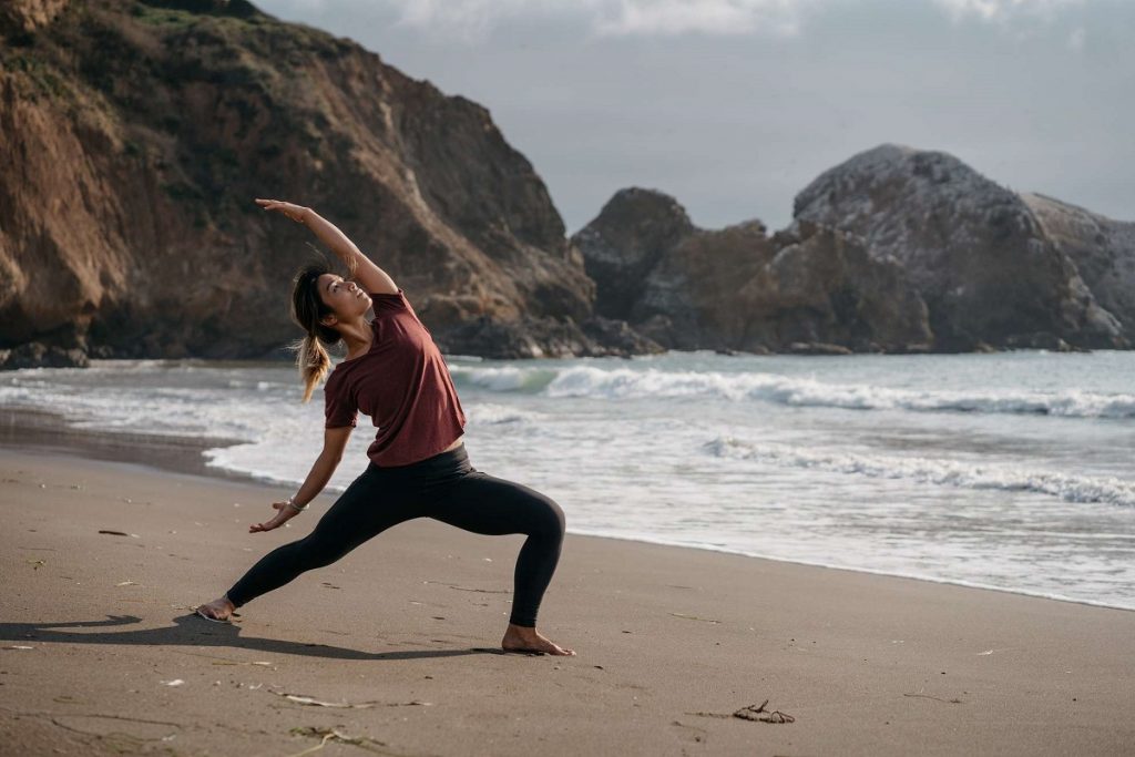 girl doing yoga position on beach