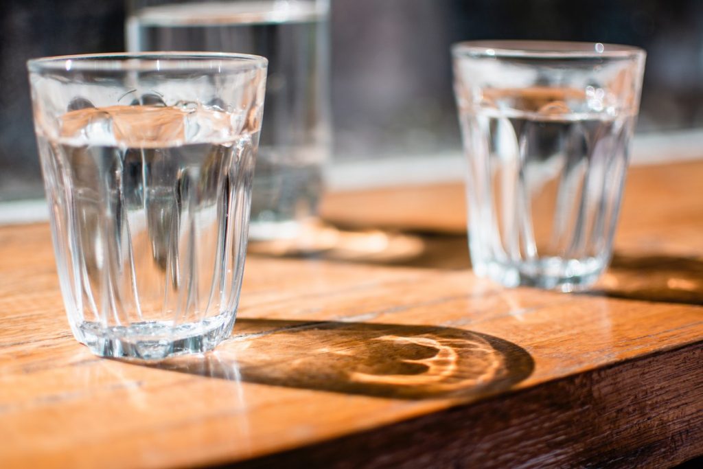 two glasses with water on the brown table