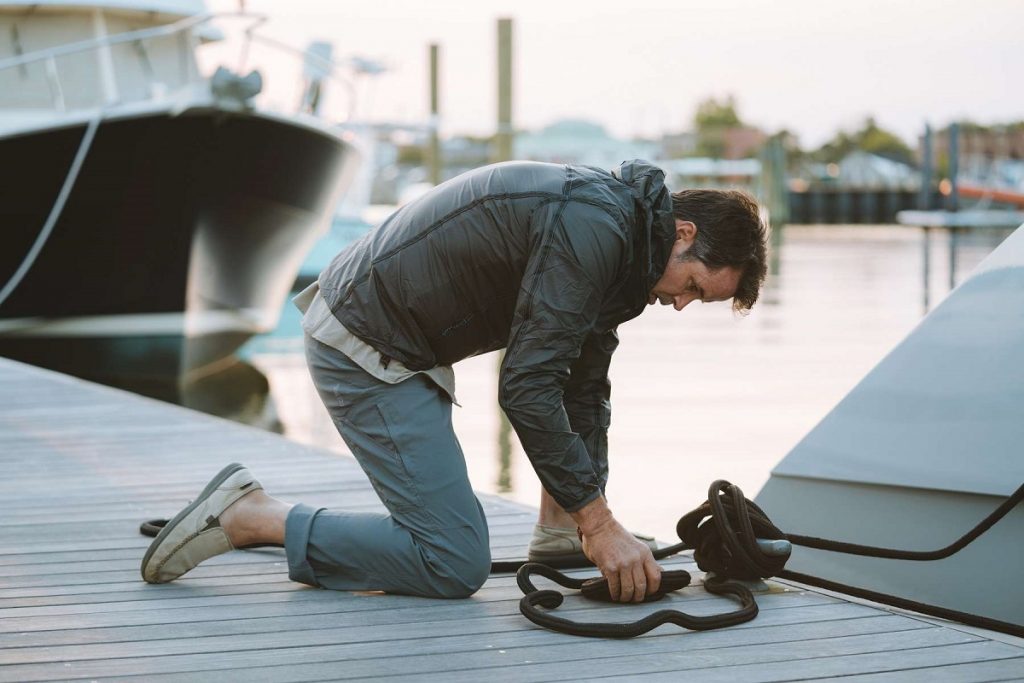 man tying up a boat to the dock