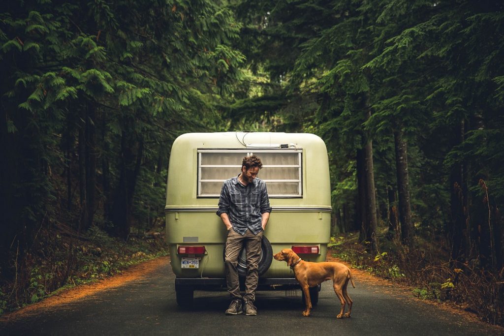 man and dog in front of camper