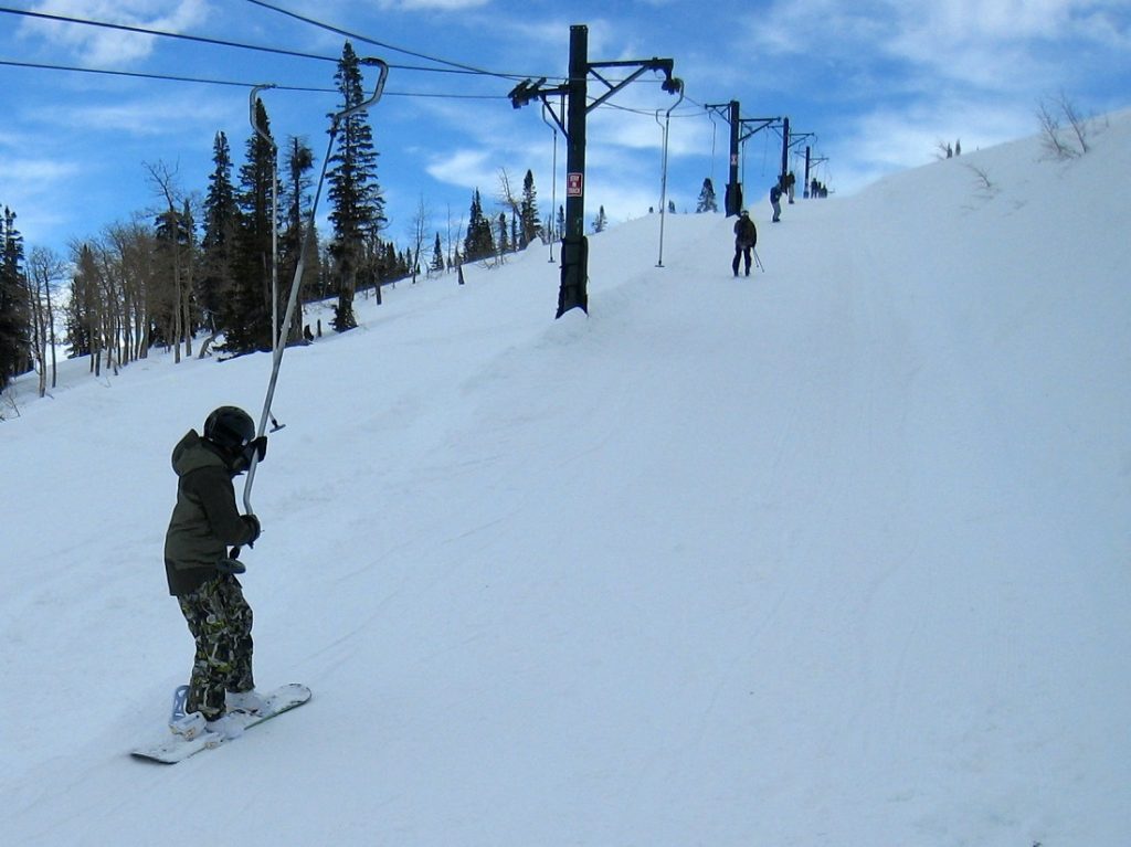 skier holding the ski lift on snowy grounds