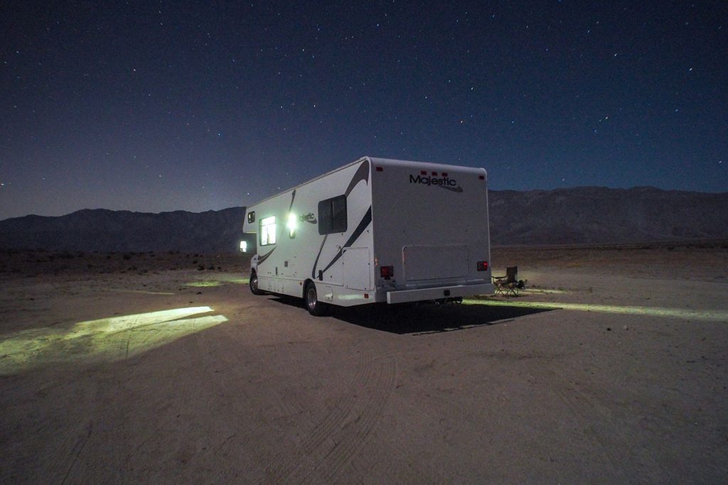 white rv in brown sand during night