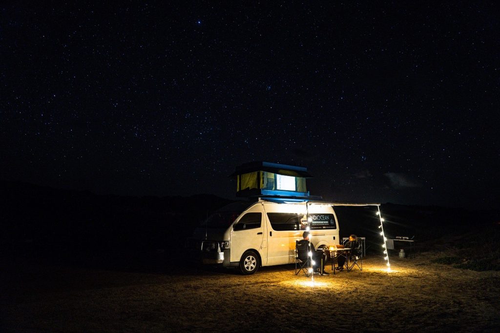 white RV on brown sand during nighttime