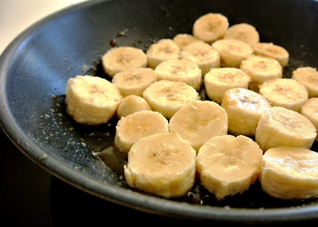 banana slices frying on black pan