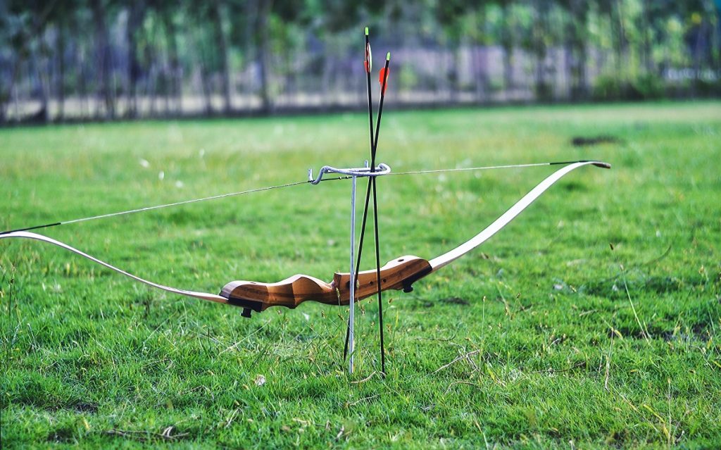 bow and arrows on green field during daytime