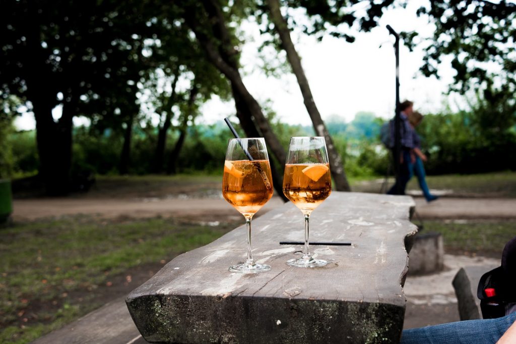 two glasses with orange liquid outdoors