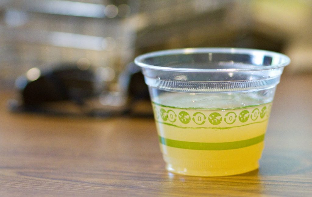 yellow liquid in small plastic cup