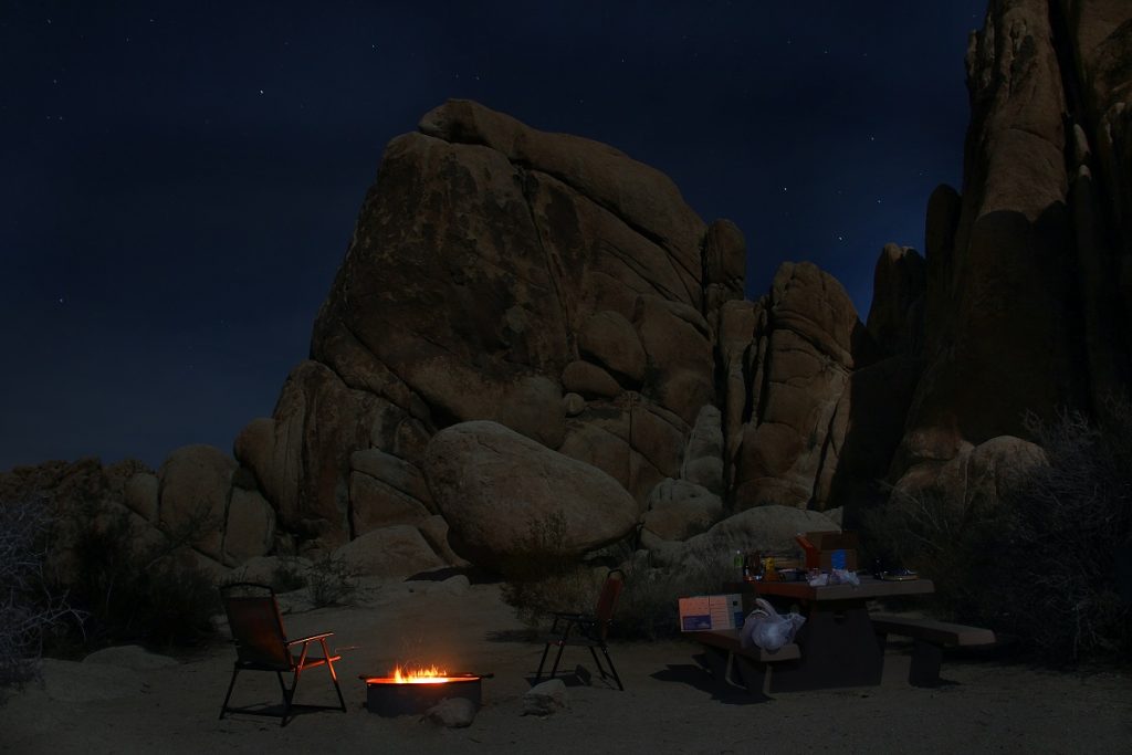 camp site under brown rock formation during night