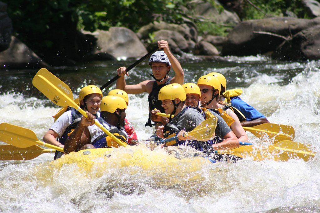 people whitewater rafting in yellow boat
