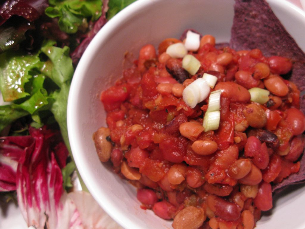 cooked brown and red beans in a white bowl