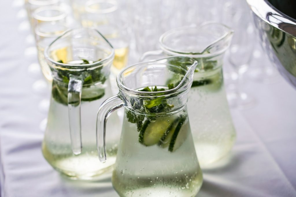 three glass pitchers with cucumber water