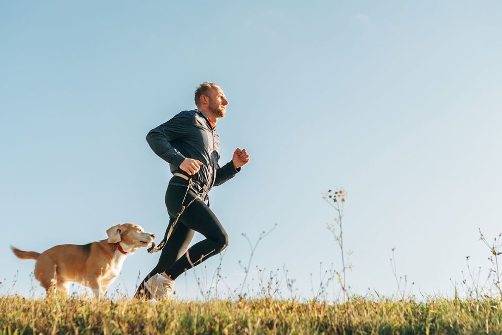 Man runs with his beagle dog