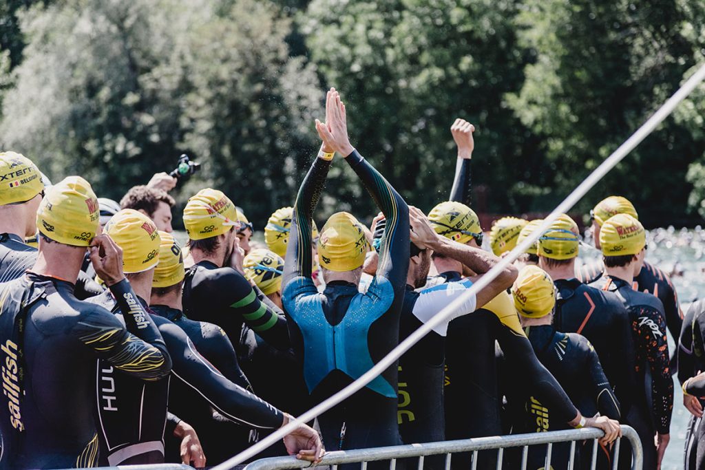 people with yellow swimming caps linning up for the start of the race