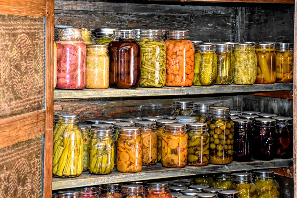 Old-fashioned root cellar showing preserved food in glass jars