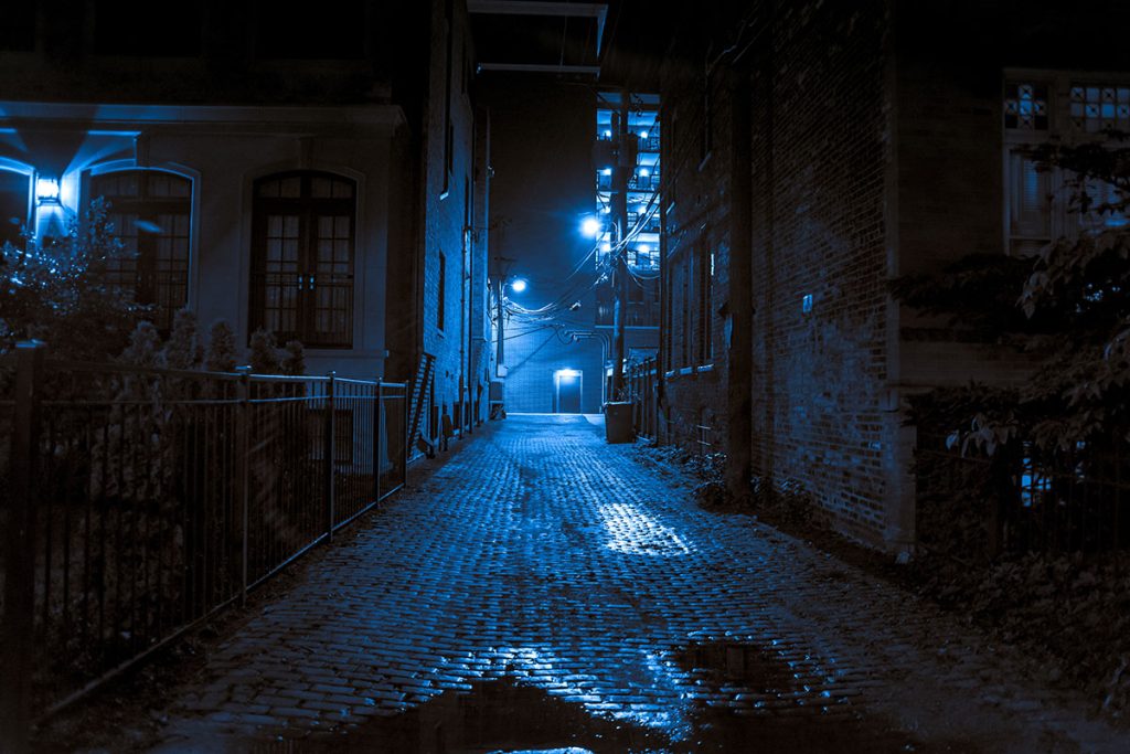 Dark and scary vintage cobblestone brick city alley