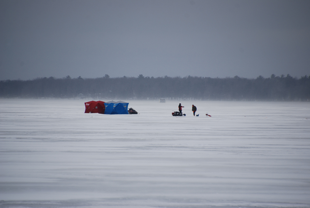 Ice fisherman near some shanties, fishing on Houghton Lake near Prudenville, MI during the second weekend of Tip-Up Town.