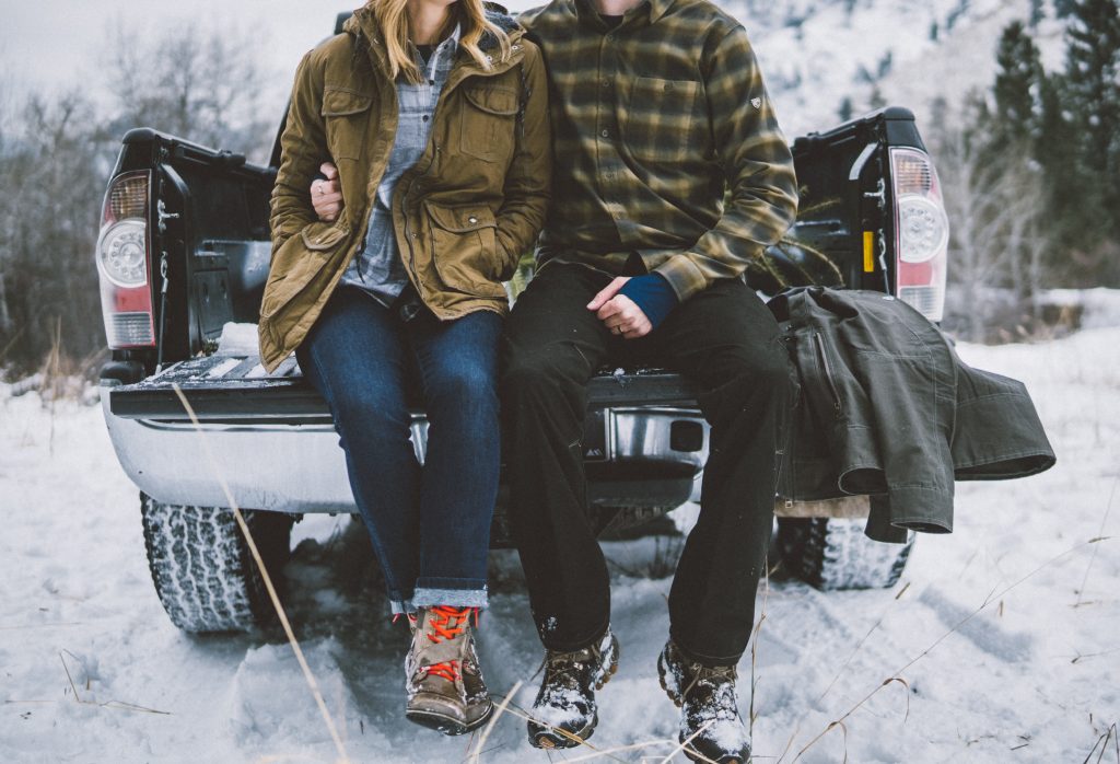 The Magic of Snow: a man and a woman sitting on a back of a truck clad in KUHL clothing.