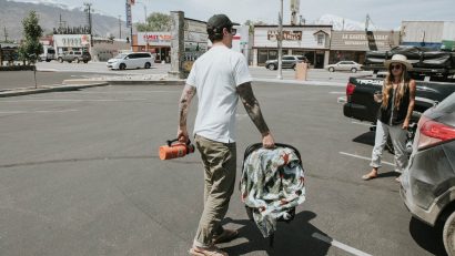 Dads Passion for Desert Hikes - Dad carrying a baby on a parking lot