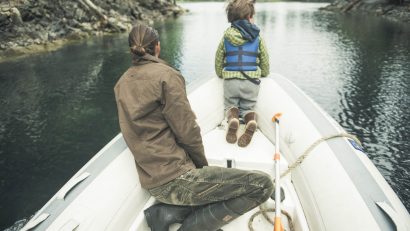 Lessons from Dad - a man and his son looking down the lake in a boat