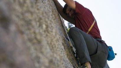 Resistor Series - A man climbing up a rock in KUHL Resistor Rock pant.