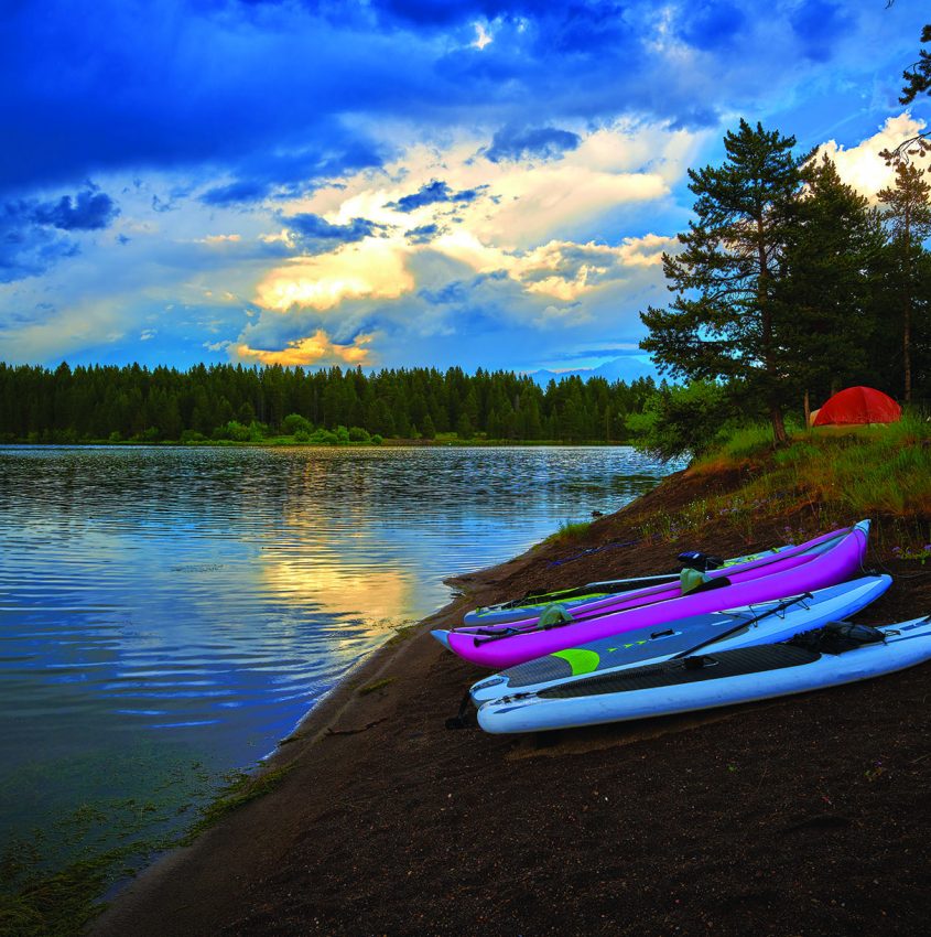 Storm clouds along Hebgen Lake with paddleboard and kayaks