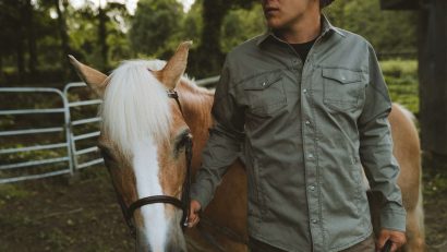 A man in a jacket holding a horse