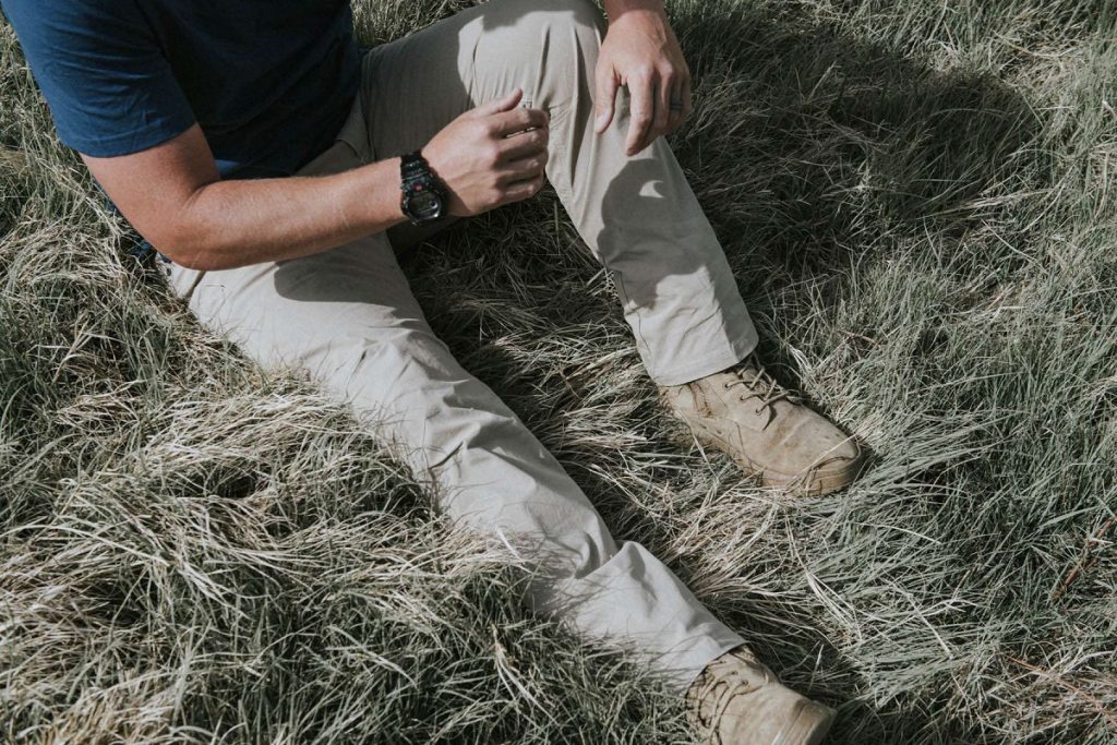 men in blue shirt and gray pants sitting in grass