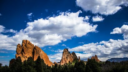 red rock formation under blue sky with white clouds