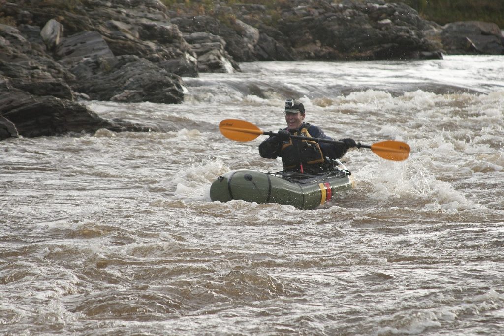 man paddling in white water