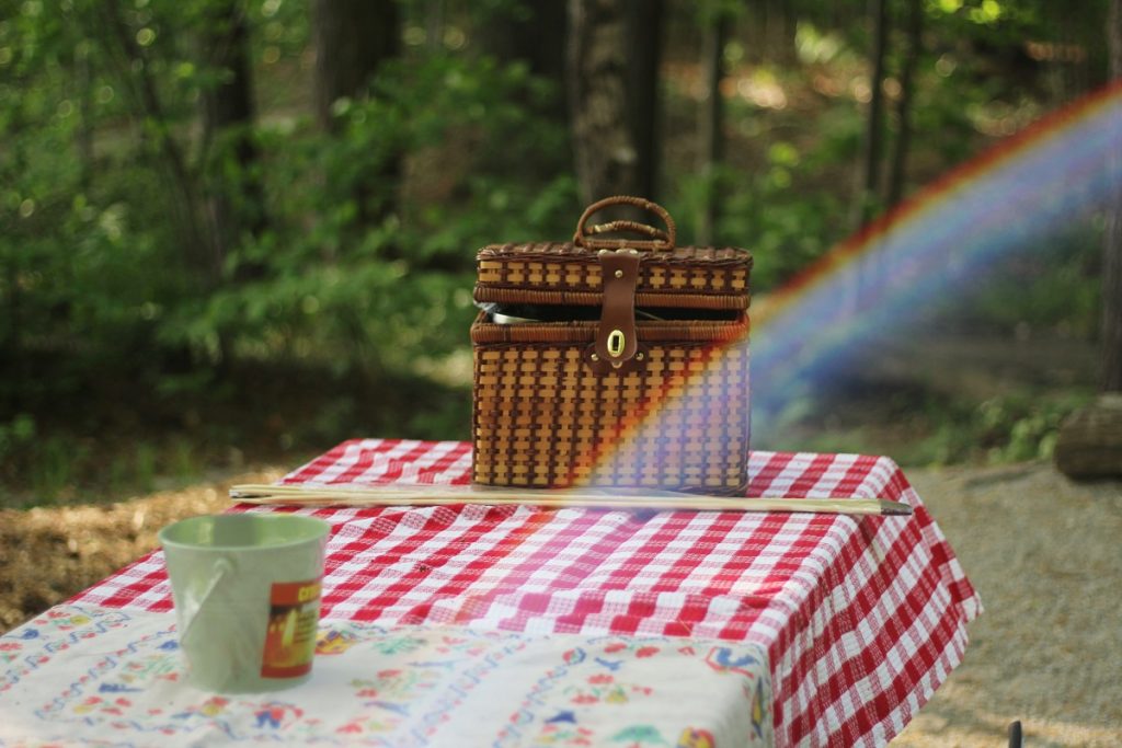 brown picnic food basket on red tablecloth