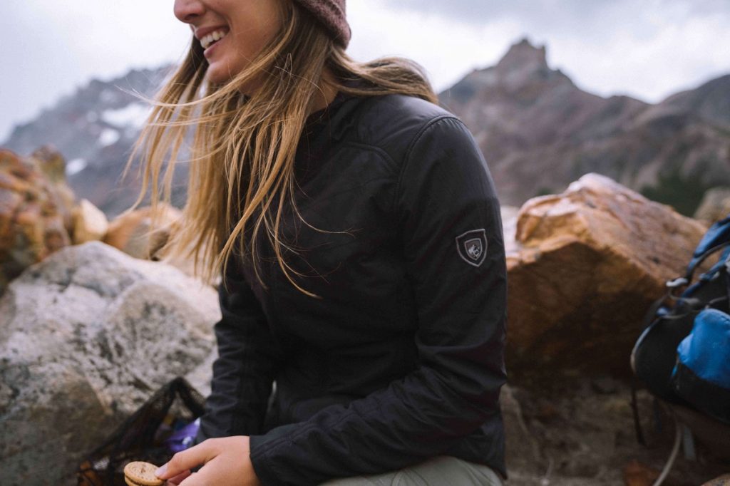 girl wearing KÜHL black jacket laughing outdoors