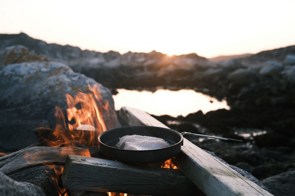 black round bowl on campfire